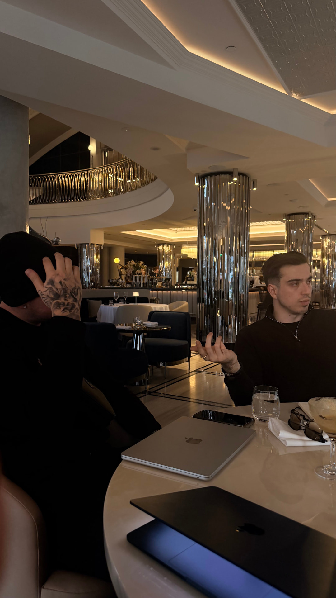 A conversation over laptops at a café