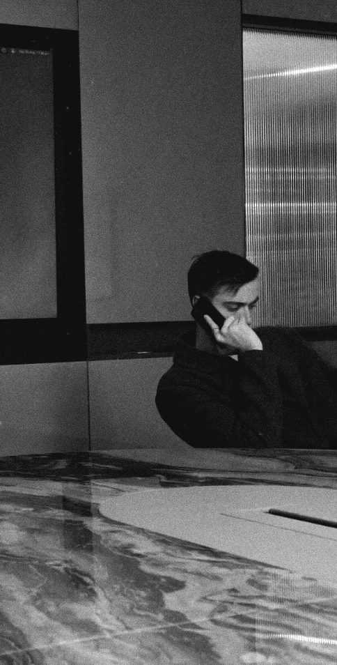 Tom Barclay taking a call at a table